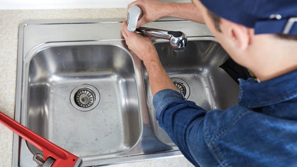 Fontanero arreglando grifo del fregadero